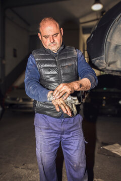 Portrait Of Mechanic Cleaning Dirty Hands Of Grease In Workshop