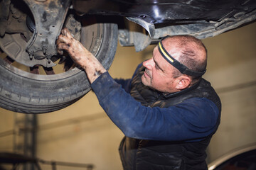 Fototapeta na wymiar mechanic supervising interior of car wheel in workshop