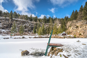Winterlandschaft mit zugefrorenem See und Leiter