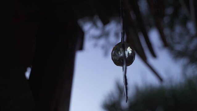 Silhouette of Feng Shui crystal ball hanging and rotating.