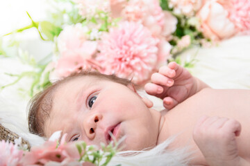Obraz na płótnie Canvas Newborn baby girl , with pink flowers background