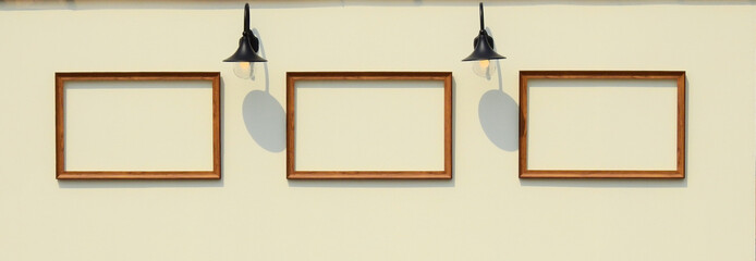 Wooden frame on the yellow wood wall with lamp