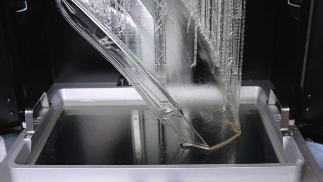 Close Up to the Build Chamber of a Resin 3D Printer that is Creating the Final Layers for a Car's Full-size Headlight Lens