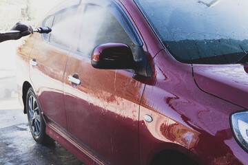 Car detailing - the man holds the microfiber in hand and polishes the car. Selective focus.