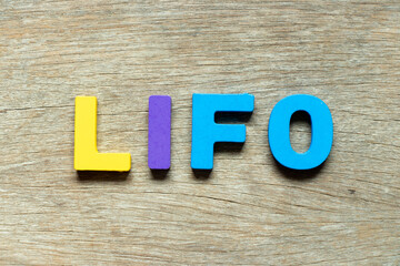 Color alphabet letter in word LIFO (abbreviation of last in first out) on wood background