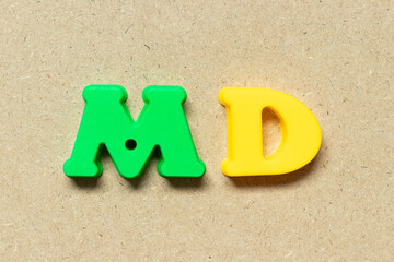 Plastic alphabet letter in word MD (abbreviation of doctor of medicine or managing director) on wood background