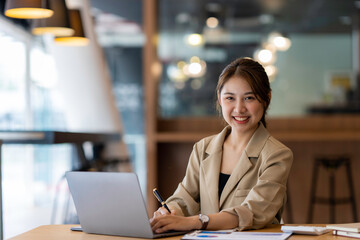 Young Asian businesswoman working with a laptop with documents at the office.