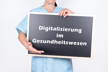 Ärztin mit einer Tafel auf der Digitalisierung im Gesundheitswesen steht