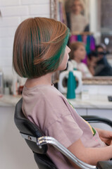 Teenage girl with colored green hair in a bob hairstyle