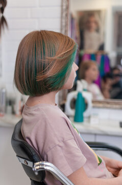 Teenage girl with colored green hair in a bob hairstyle