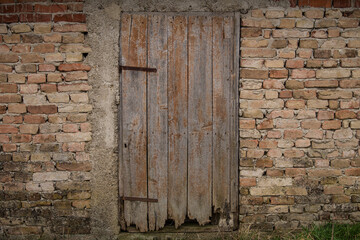 Naklejka premium Sunja, Croatia, 05,04,2021: Old wooden rustic doors on rural home wall.