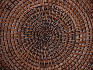 Beautiful pattern on handmade woven basket. Detail of wicker artwork background with circle structure. Texture of round traditional crafted handicrafts rattan tray. Natural brown bamboo furniture