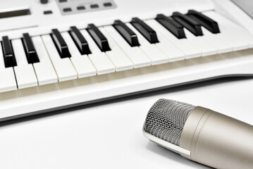 Professional studio microphone against blurred synthesizer keyboard background. Professional studio...
