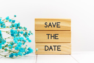 Save the date quotes on wood block with blue baby breath flower white background