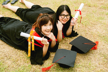 Teenage Asian woman graduates wearing their cap and gown  happy to graduate with bachelor degree....