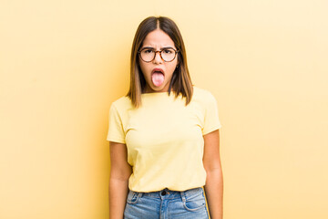 pretty hispanic woman feeling disgusted and irritated, sticking tongue out, disliking something...