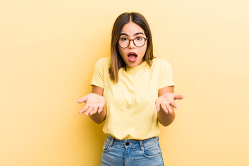 pretty hispanic woman feeling extremely shocked and surprised, anxious and panicking, with a...