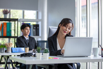 Portrait of Asian beautiful business woman working at the office, using computer on table.