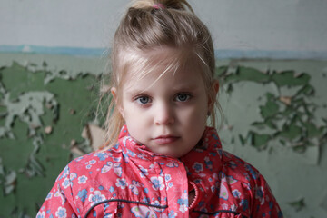 Portrait of little sad girl in ruined building. Refugees, war crisis, humanitarian disaster concept.