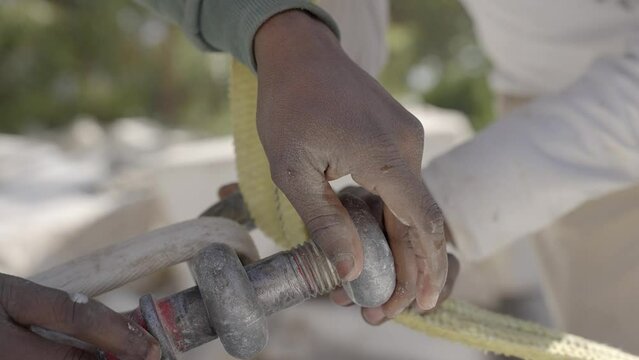 Riggers' Hands Securing Shackle With Clevis Pin. close up