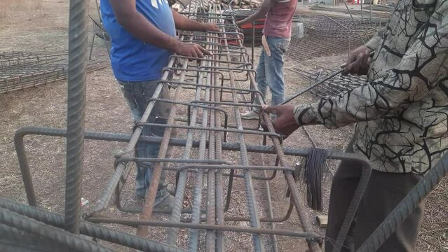 Making RCC Column after Design on Site. Construction workers attach steel rings to columns and beams. - Reinforcement concrete column as part of building structure at the construction site