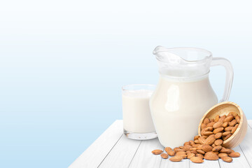 Glass of Almond milk and almond seeds in wooden bowl isolated on wood table 