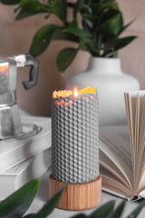 Grey bee wax candle in bedroom. White vase with leaf