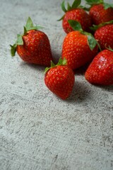Fresh strawberries on cement background, space for text