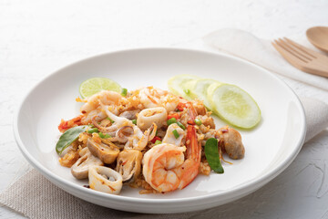 Seafood Tom Yum Fried Rice,Stir fried rice with shrimp squid and straw mushroom with sauce on white plate
