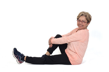 side view of senior woman sitting on the floor looking at camera on white background