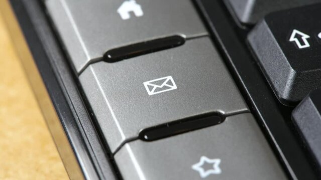 Finger pressing an email button, user, man pushing the e-mail client shortcut key with an envelope symbol icon on a simple keyboard, sending e mails, messages, online communication abstract concept