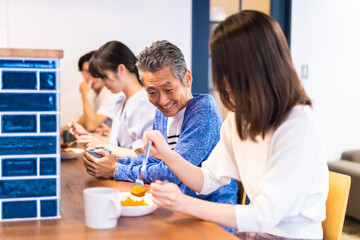レストランのカウンター席でご飯を食べる人々