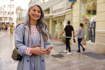 Fototapeta premium Trendy Asian woman walking outdoors in town