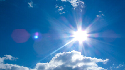 Naklejka na ściany i meble sun on the background of a blue sky with white clouds
