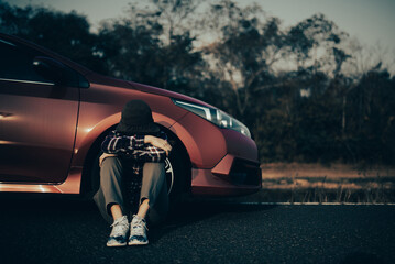 Young woman handsome man sitting by the Broken Down car