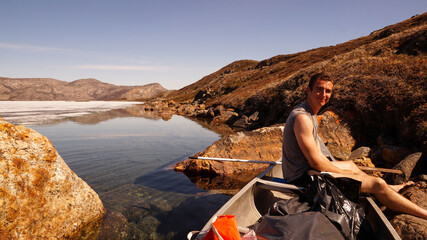 Hikers on the Arctic Circle Trail in a canoe on a lake between Kangerlussuaq and Siimiut in...