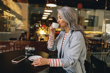 Modern Asian lady relaxing at street cafe