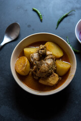 Indian style chicken curry served in a bowl on a dark background. Close up, selective focus.