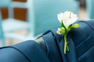 white flower on the lapel of the groom's coat