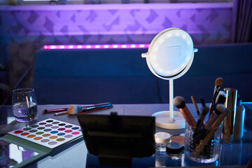 Colorful cosmetics on blue wooden workplace. Cropped view of picturesque devices