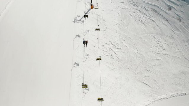 Aerial view of Livigno ski resort in Lombardy, Italy. Chairlifts, ski lifts, gondola cabin lifts are moving. View from above, top view. 4k video footage 