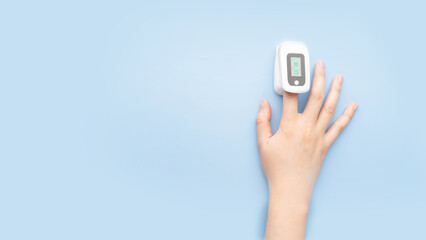 Woman using pulse oximeter finger digital device to measure oxygen saturation in blood and pulse...
