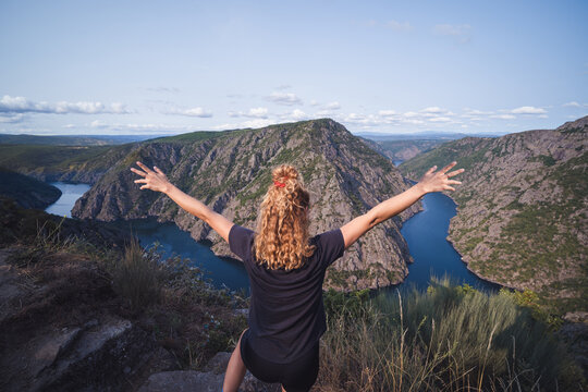 Woman standing on top with outstretched arms