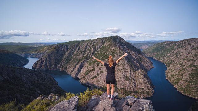 Woman standing on top with outstretched arms