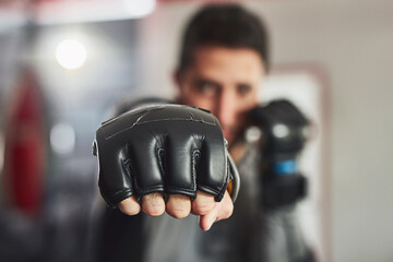 Coming at you full force. Cropped portrait of a professional fighter training in the gym.