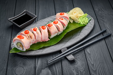 Sushi roll dragon with tuna and spicy sauce