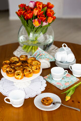 Traditional portuguese cakes called Pasteis de Belem on laid table with white lace napkins 