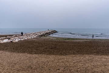 Meeresufer mit Landungssteg aus Stein und Nebel am Meer