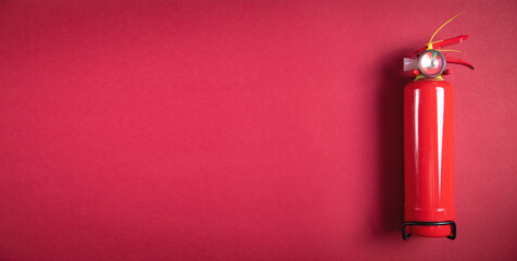 Fire extinguisher on the burgundy background.