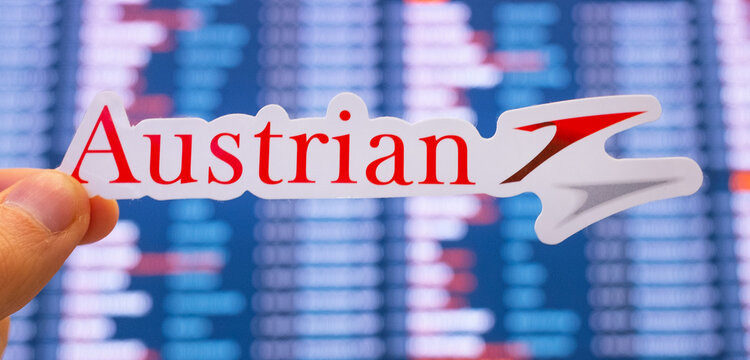 December 11, 2021, Vienna, Austria. The emblem of Austrian Airlines against the background of an electronic board with flight schedules at the international airport.